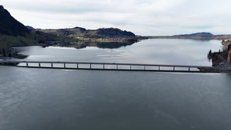 Steinbach-Viaduct-over-Lake-Sihl,-Euthal-SZ-with-calm-waters-and-surrounding-hills,-aerial-view