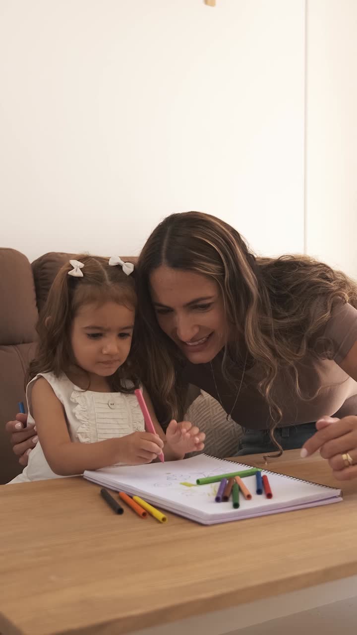 Loving mother and daughter drawing on sofa at home