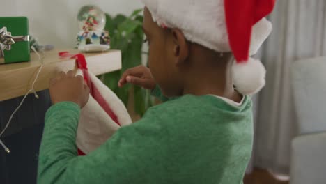 niño afroamericano en busca de un regalo en las medias en tiempo de navidad