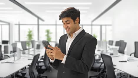 happy indian manager talking to someone on text