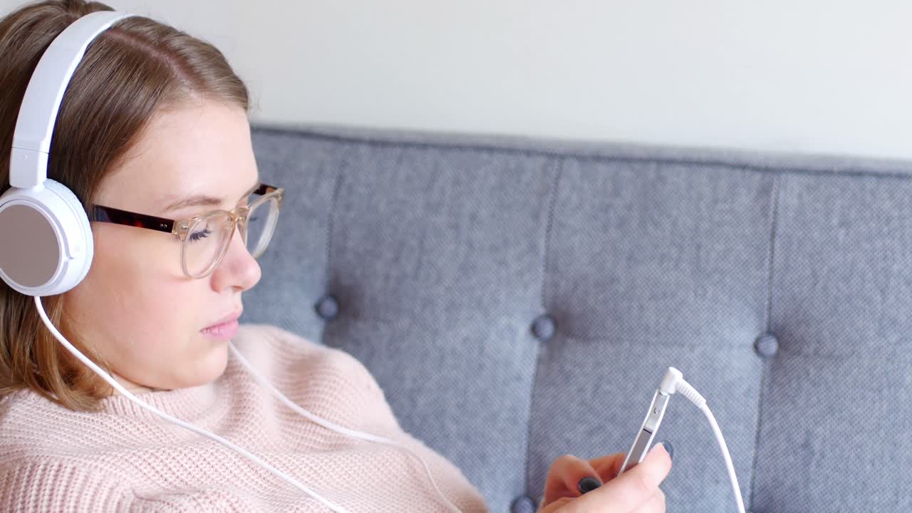 mujer escuchando música con auriculares de su teléfono móvil