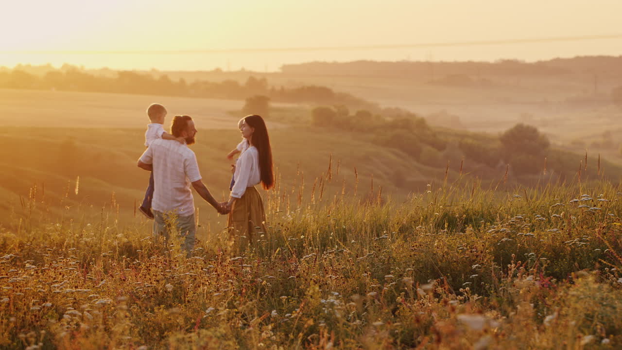 수평선 스카이라인 태양 너머로 떠나는 태양을 호위하는 두 어린 아들과 함께 있는 젊은 재미있는 커플