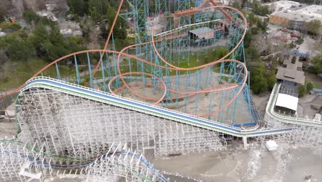 montaña mágica de seis banderas sobre paseo extremo en montaña rusa coloso torcido en el parque, vista aérea de seguimiento de drones