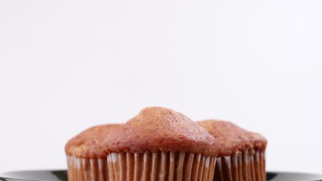 Muffins-Banana-Con-Fondo-Blanco-Enfoque-Superficial-Y-Girando-Lentamente