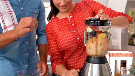 pareja preparando un batido juntos
