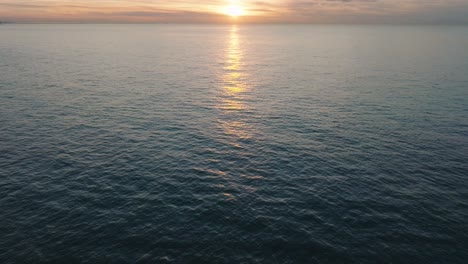 Aerial-establishing-view-of-abandoned-seaside-fortification-buildings-at-Karosta-Northern-Forts-on-the-beach-of-Baltic-sea-in-Liepaja,-sunset,-golden-hour,-wide-drone-shot-moving-forward,-tilt-up