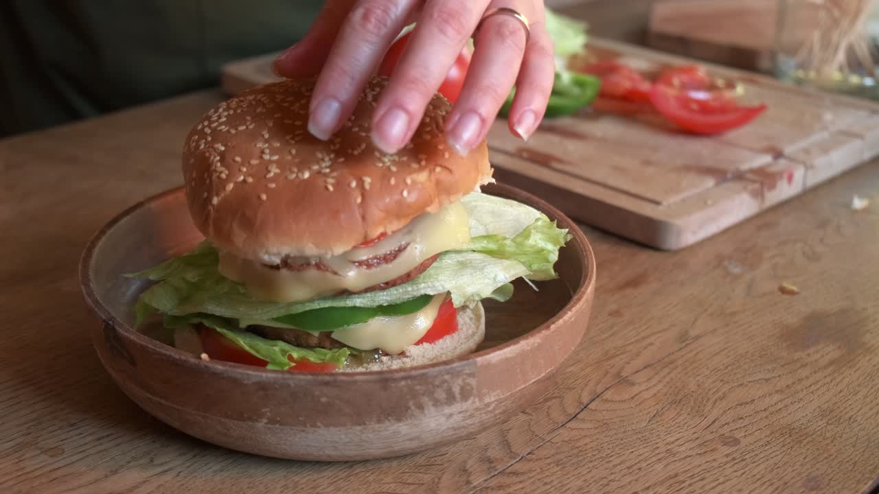 cocinar terminando de preparar una deliciosa hamburguesa vegetariana vegana con tomate y pimiento en cámara lenta de 4k