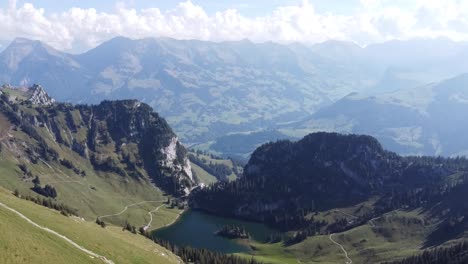 deep blue mountains lake in a juicy green valley surrounded by forest in switzerland