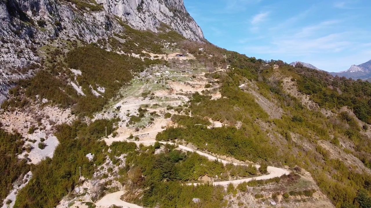 Riprese aeree sopra una strada sterrata che sale sulla montagna rocciosa in Albania. Vista panoramica suggestiva