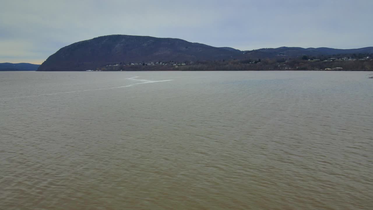 겨울 동안 눈으로 뒤덮인 먼 산들과 넓은 강 계곡의 공중 영상