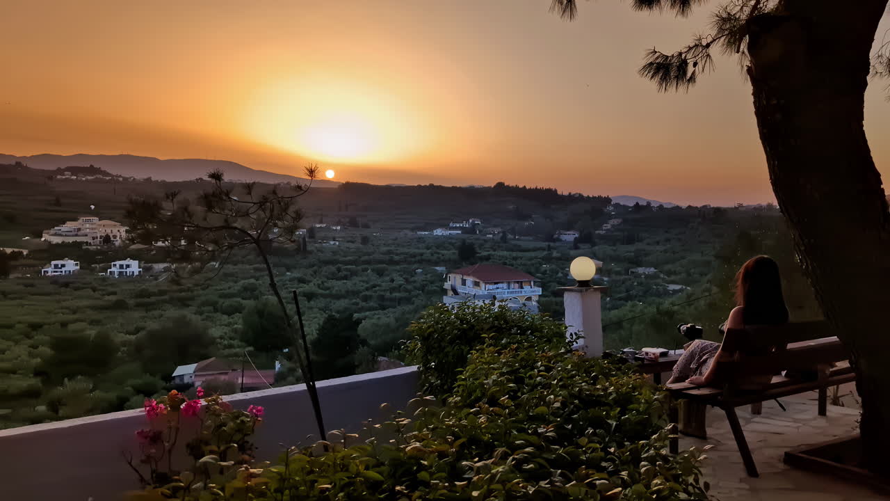 그리스에서 만적이고 황금빛 해가 지는 것을 즐기는 아름다운 여성