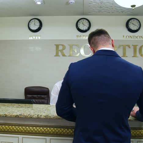 man near reception desk in hotel