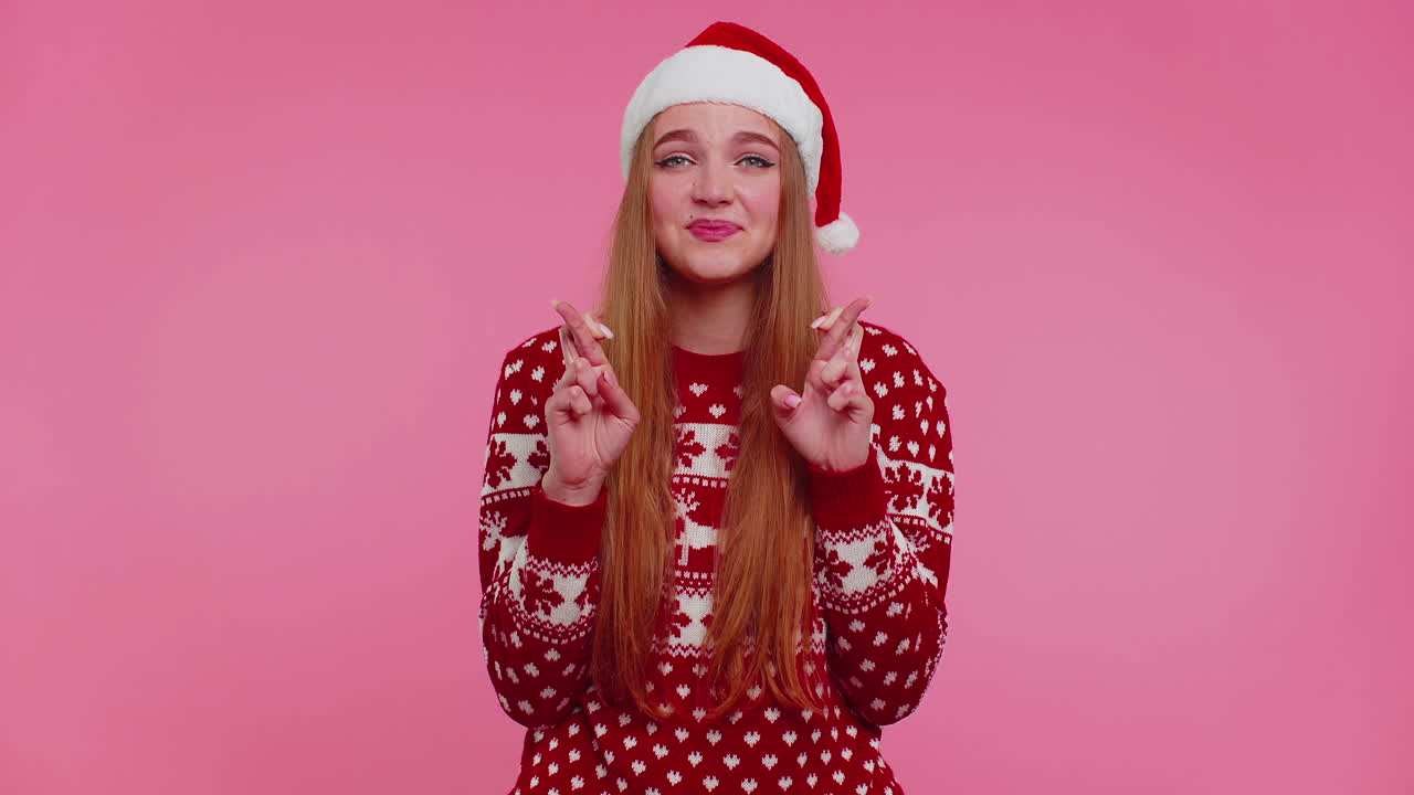 크리스마스 스웨터에 있는 여성은 행운을 기원하며 오랫동안 기다렸던 선물을 받으면서 기합니다.
