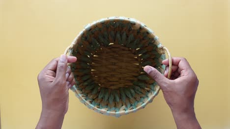 hands holding a woven straw basket