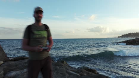 drone flies toward pilot standing on breakwater in varazze in italy