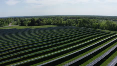 Toma-Aérea-Sobrevolando-E-Inclinándose-Hacia-Abajo-En-Una-Gran-Granja-Solar-En-La-Zona-Rural-De-Minnesota.