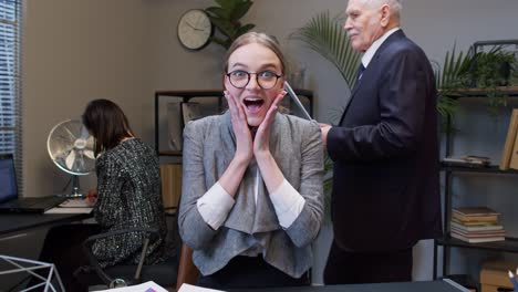 Young-shocked-business-woman-accountant-reading-documents-analyzing-financial-papers-raising-hands