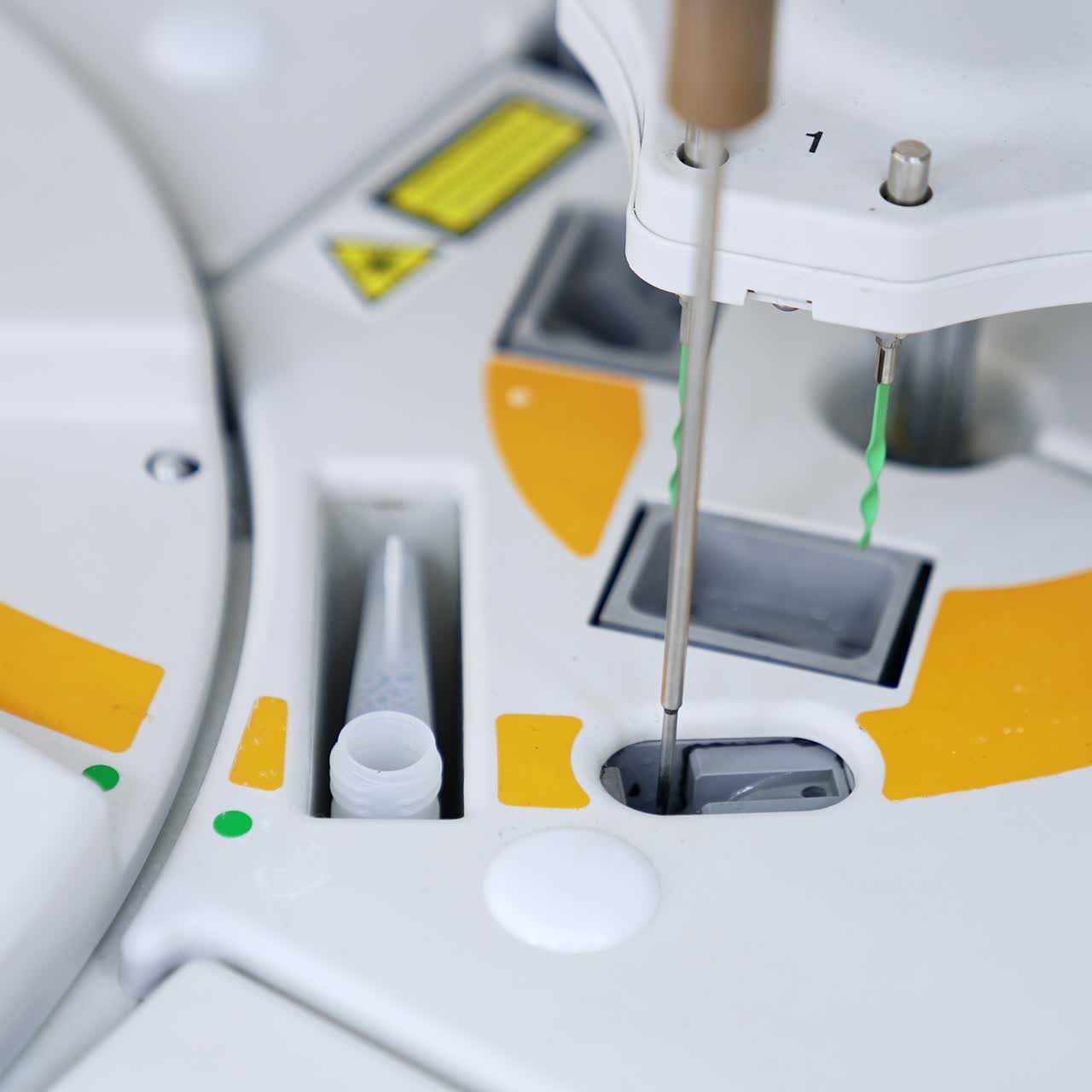 Slots at the medical testing equipment with metal needle moving from one slot to another. New equipment at modern science laboratory
