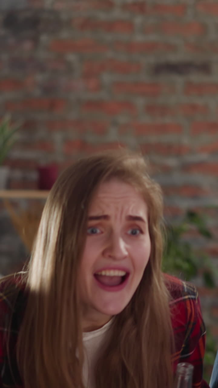 mujeres jóvenes emocionadas abrazan y beben cerveza viendo un partido de fútbol con chicos negros en un apartamento a cámara lenta. fanáticos del deporte felices grupo multinacional en el campeonato