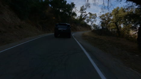 cinematic fpv following shot of a police car driving through a country road