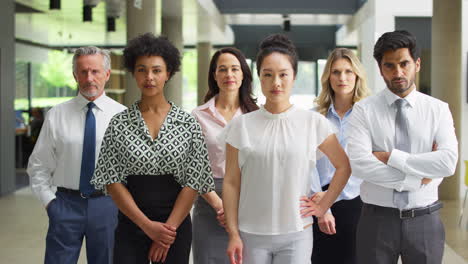 portrait of serious multi-cultural business team inside modern office lobby