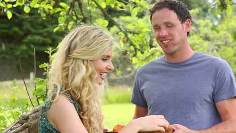 Linda-Pareja-Comiendo-Manzanas-Juntos-En-Un-Jardín