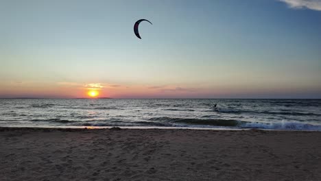 Ein-Atemberaubender-Sonnenuntergang-Malt-Den-Himmel,-Während-Ein-Windsurfer-Auf-Dem-Ruhigen-Wasser-Des-Asowschen-Meeres-In-Der-Nähe-Der-Krim-Gleitet