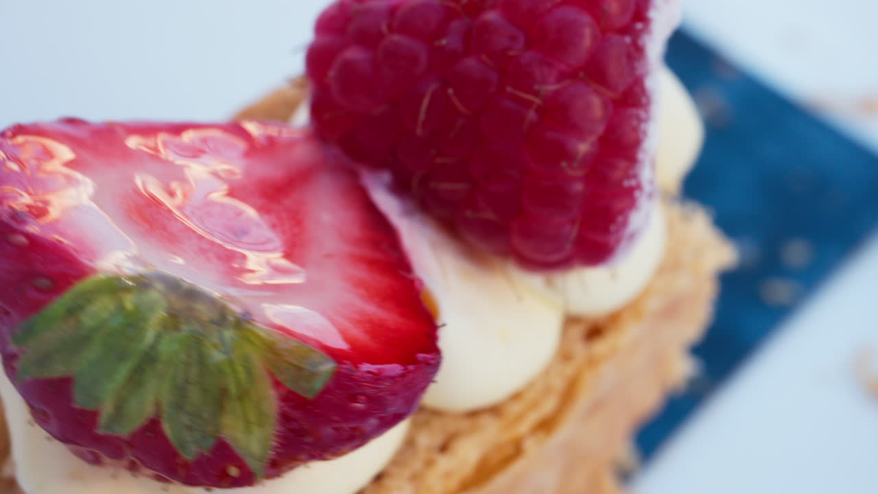 Close up of a pice of cake with cream and berries on top