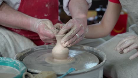 potter teaching pottery little girl