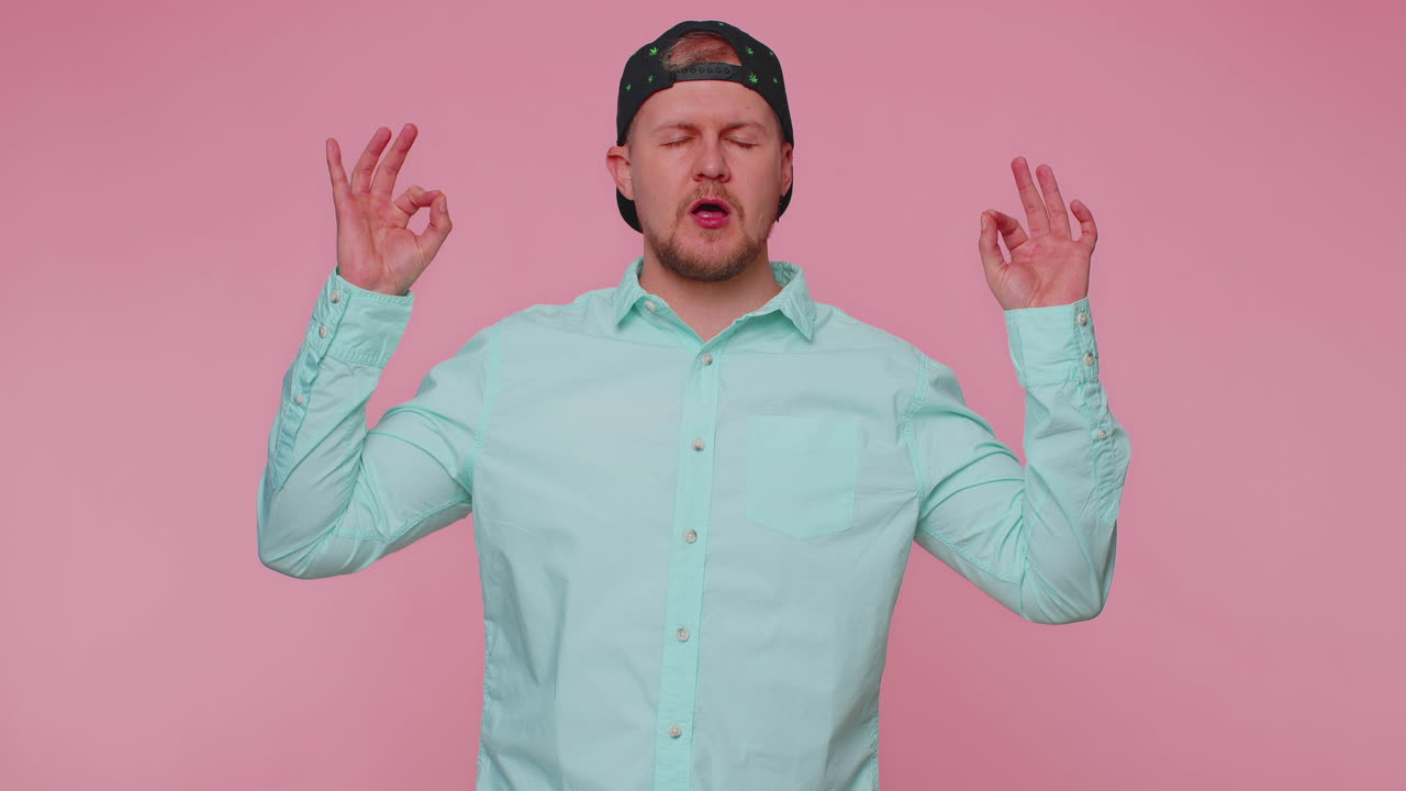 사람은 무드라 몸짓으로 깊이 숨을 들이마시며, 눈을 감고, 집중된 생각으로 명상하며, 평화롭습니다.