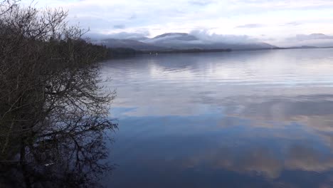 view of loch lomond and mountains on a calm day with still water