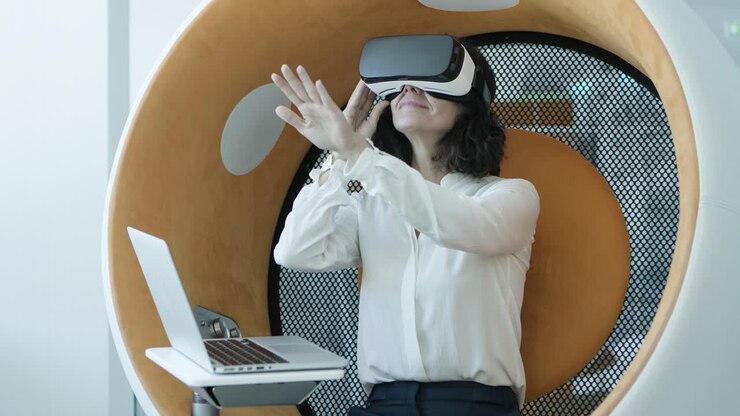 Donna con laptop che usa un visore VR