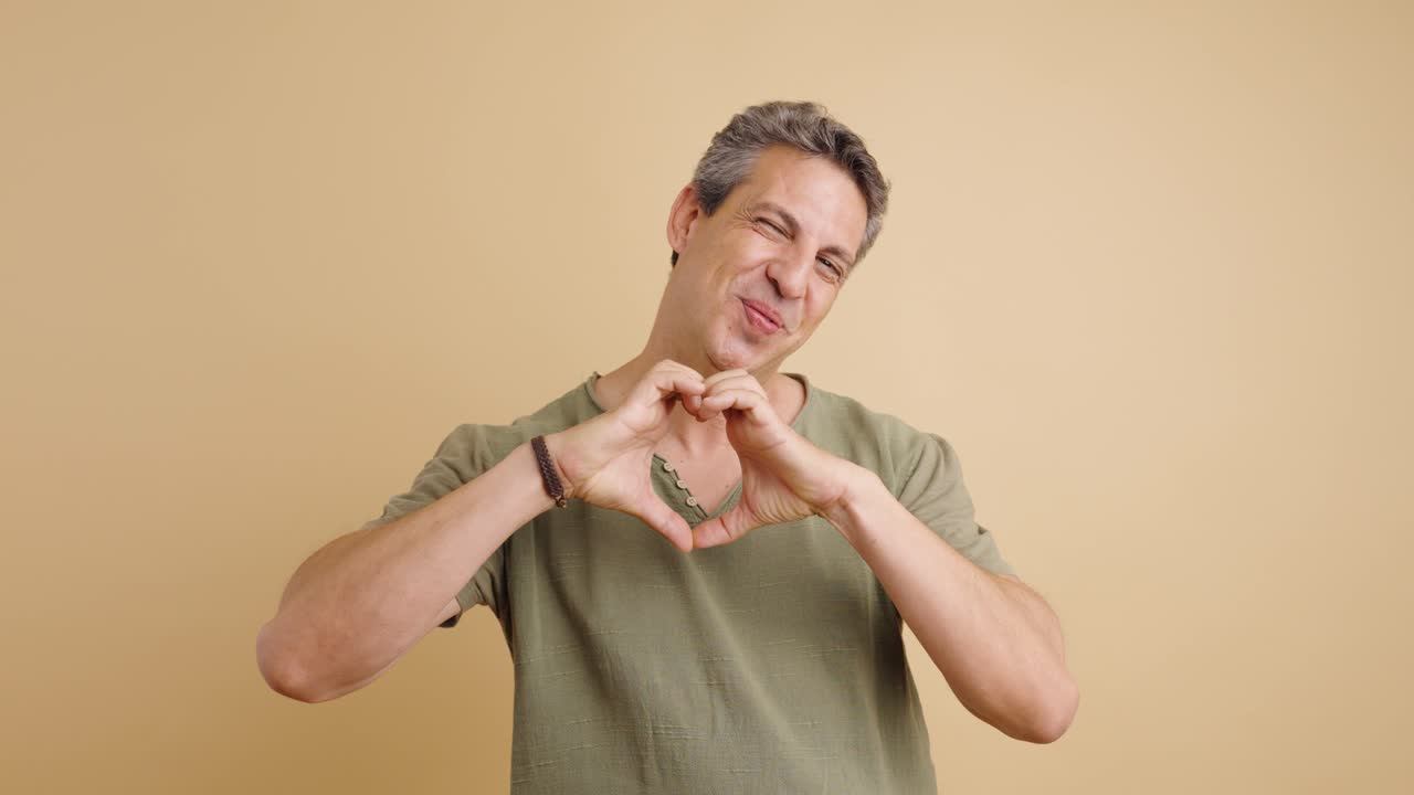 hombre haciendo una forma de corazón con sus manos