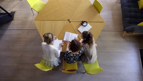 female students studying together in library, top view