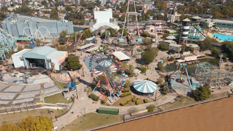 Vista-Aérea-Diurna-De-Los-Paseos-Del-Parque-De-Diversiones-En-El-Parque-Costa-A-Lo-Largo-Del-Río-Lujan-En-La-Ciudad-De-Tigre,-Buenos-Aires,-Argentina