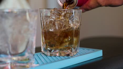 slow motion pouring coke into an alcoholic mixed drink