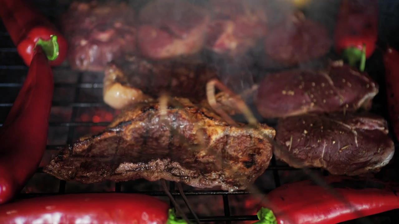 Carne grelhada com marcas de grelha visíveis sendo virada enquanto cozinha sobre brasas quentes, acompanhada de vegetais.
