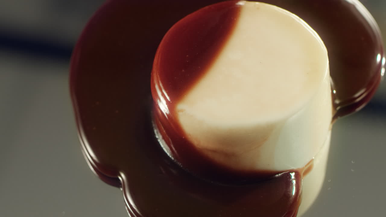 dulce caramelo vertiendo en pastel blanco. sabrosa panna cotta con salsa de chocolate