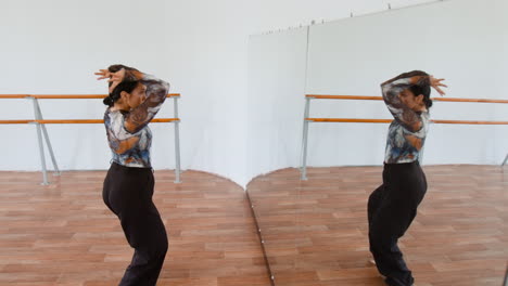 woman practicing contemporary dance in a studio with mirrors
