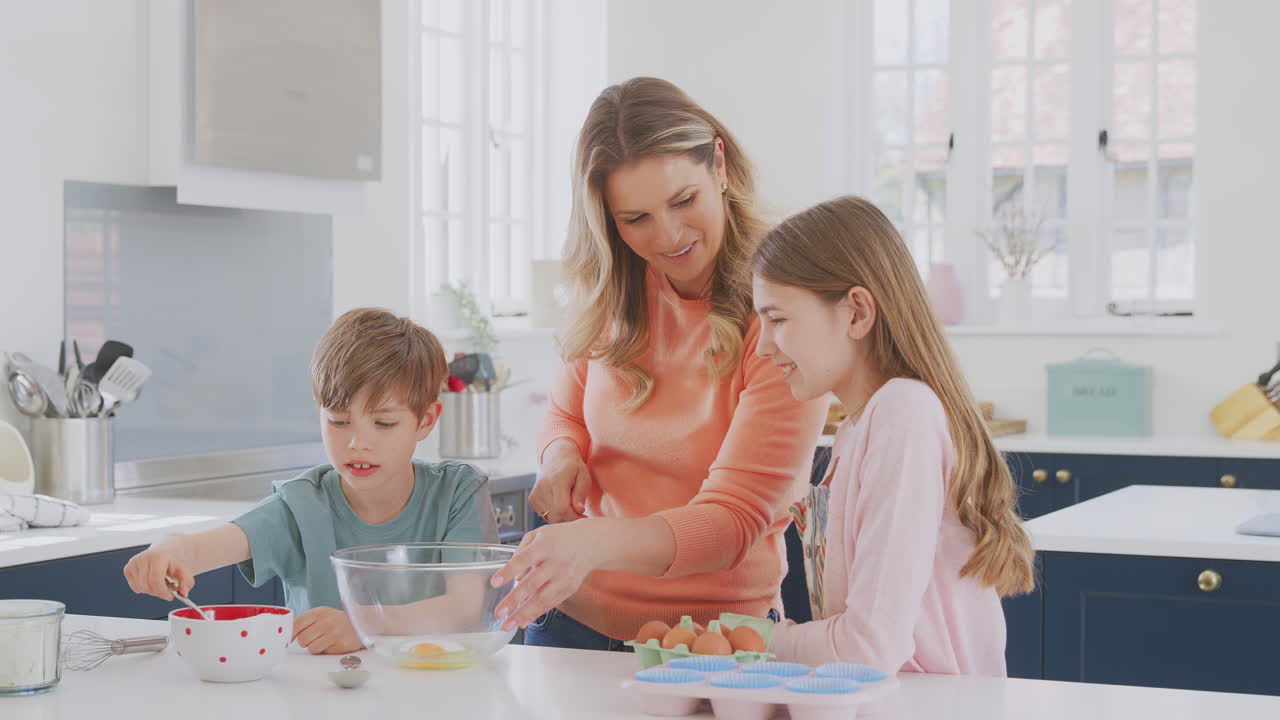 집에서 주방에서 두 아이와 함께 재미있는 베이킹 케이크를 즐기는 어머니