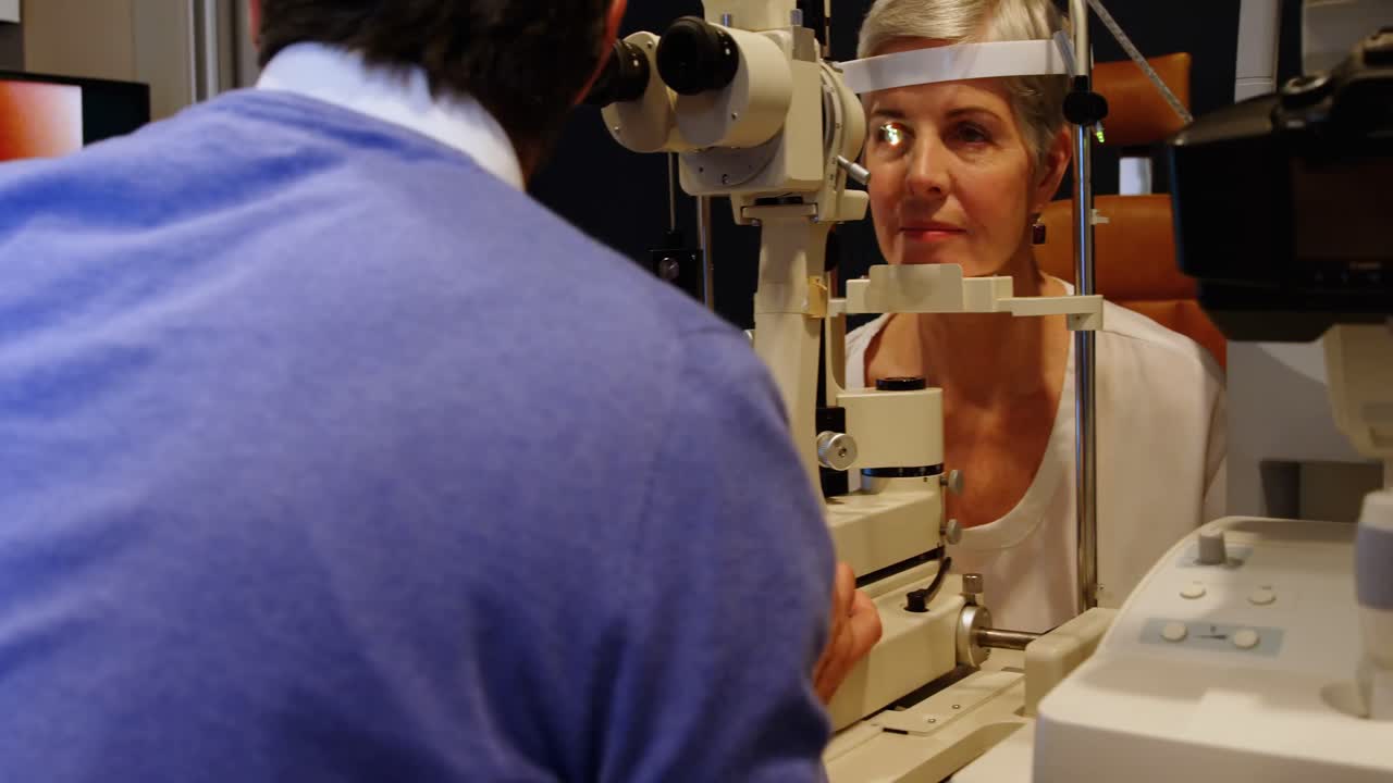 optometrista che esamina gli occhi del paziente con una lampada a fessura 4k