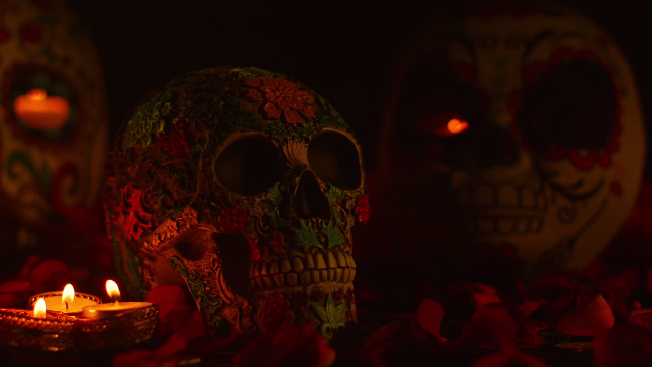 불과 꽃잎으로 둘러싸인 장식된 두개골의 정체물이 멕시코의 dia de los muertos (죽은 날) 을 축하하고 있습니다.