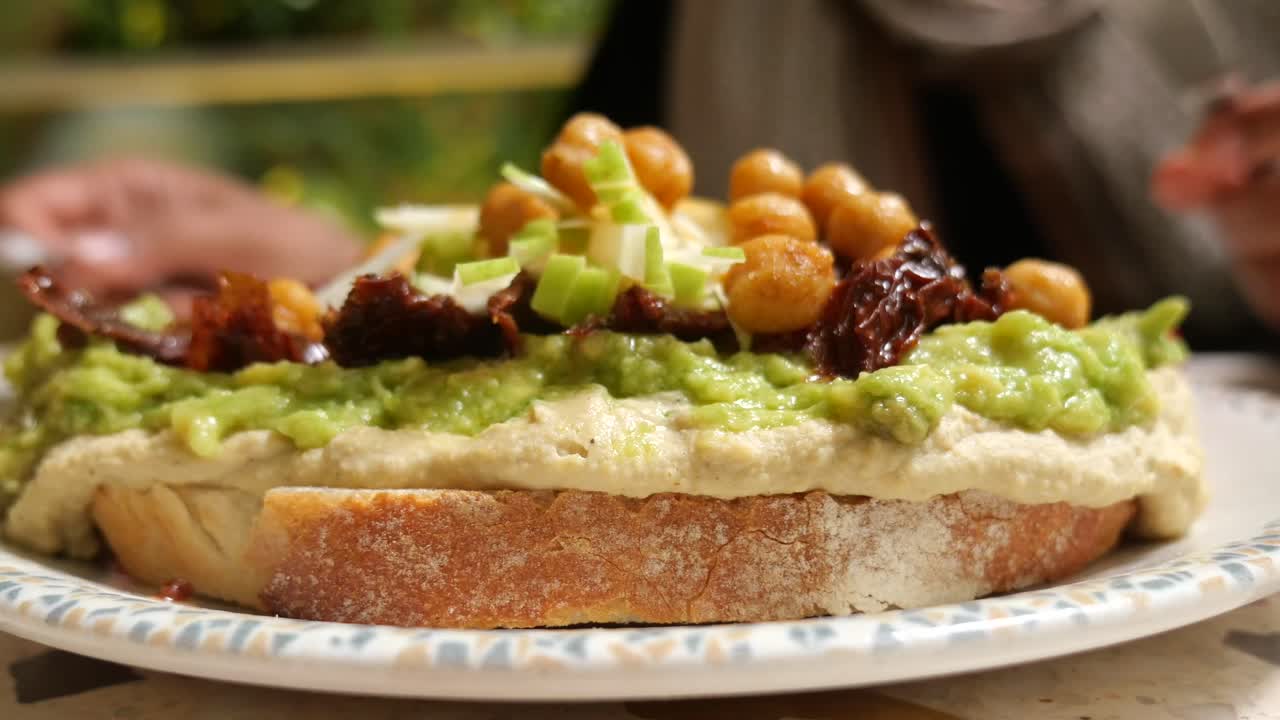 Open sandwich with hummus, avocado and toppings