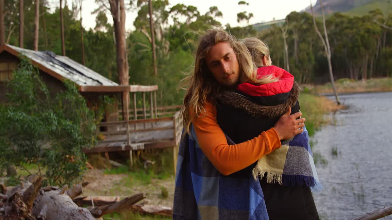pareja romántica abrazándose cerca del lago 4k