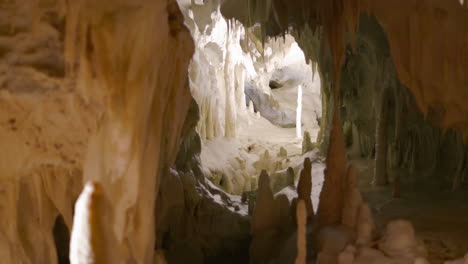 Frasassi-Caves,-fascinating-view-of-the-depths-of-the-caves-covered-in-very-white-calcite-and-full-of-stalactites-and-stalagmites