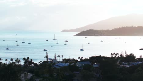 Airlie-Beach-Bay-Lagoon-gateway-to-Great-Barrier-Reef-Whitsundays-Whitehaven-aerial-drone-sunrise-morning-mist-sunny-coastline-marina-jetty-sailboats-Coral-Sea-Marina-calm-water-static-shot