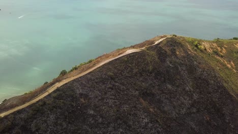 aerial circling coastal mountain with vegetation burned by fire