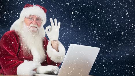 Santa-clause-sitting-in-front-of-his-laptop-combined-with-falling-snow