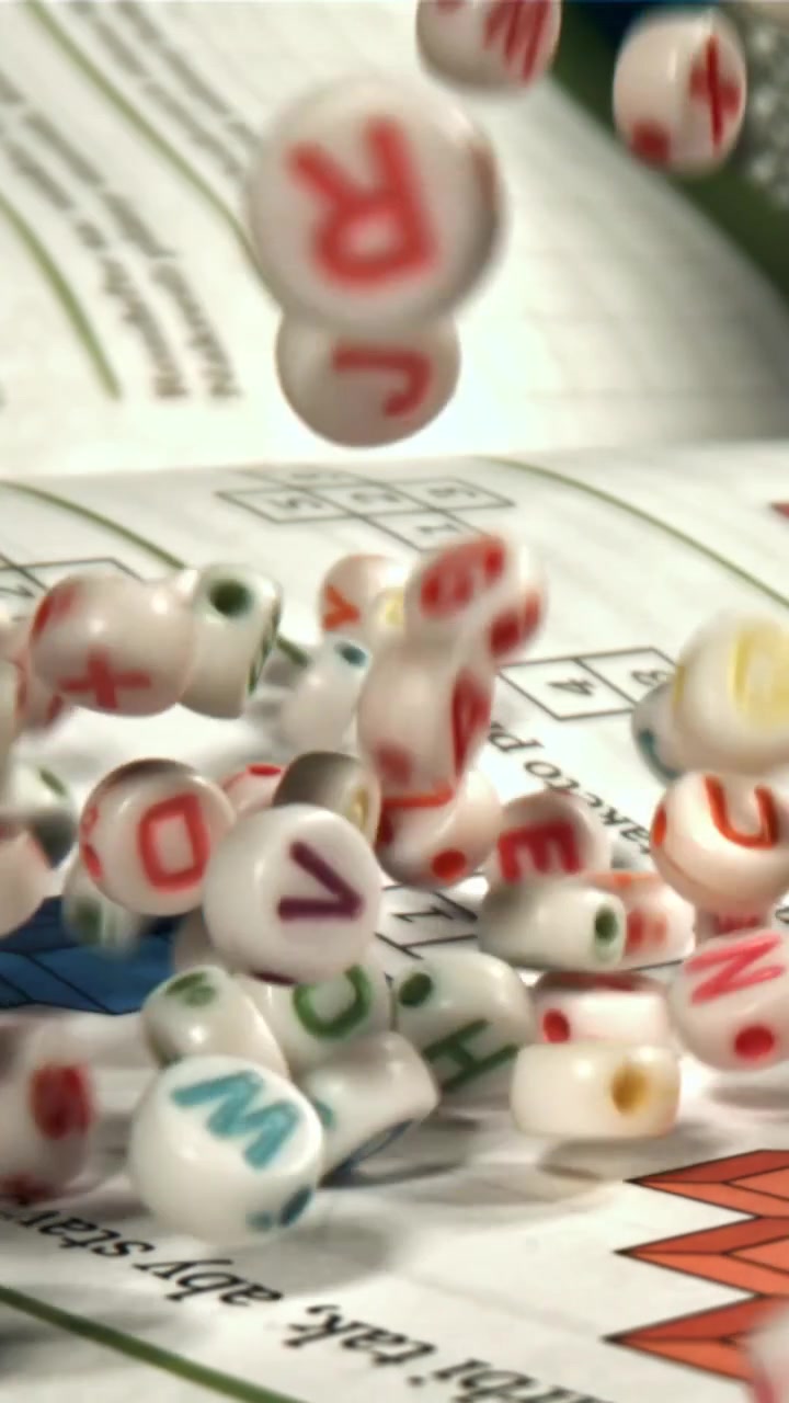 Perline colorate con lettere che cadono su una scheda educativa al rallentatore