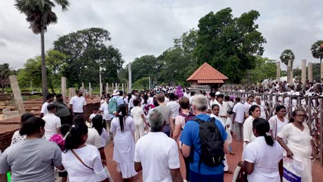 tourists and locals walking at a temple site in anuradhapura, sri lanka. captured during the daytime, highlighting cultural vibrancy and local life.